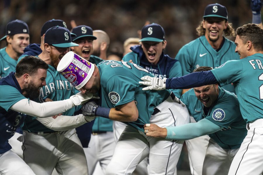 Seattle Mariners including Jesse Winker, left; Ty France, third from right; Logan Gilbert, second from right; and Adam Frazier, right celebrate a home run by Cal Raleigh in ninth inning of a baseball game against the Oakland Athletics, Friday, Sept. 30, 2022, in Seattle. The Mariners won 2-1 to clinch a spot in the playoffs. Photo Courtesy AP Photo/Stephen Brashear