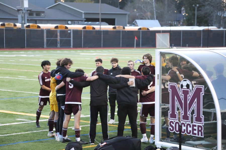 MIHS Soccer players huddle during a match.
